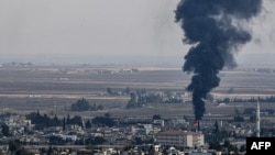 Fire and smoke rise from the Syrian town of Ras al-Ayn, Oct. 18, 2019.