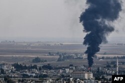 FILE - Fire and smoke rise from the Syrian town of Ras al-Ayn, Oct. 18, 2019.