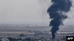 Fire and smoke rise from the Syrian town of Ras al-Ayn, Oct. 18, 2019.