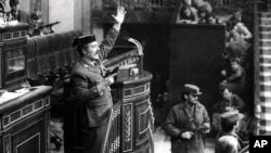 FILE - Antonio Tejero, Spanish Civil Guard, raises arm during an attempted coup in the Spanish Parliament, Madrid, Spain, Feb. 23, 1981.