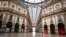 FILE - In this March 22, 2020 photo, a man walks in an empty Vittorio Emanuele II gallery shopping arcade in downtown Milan, Italy.