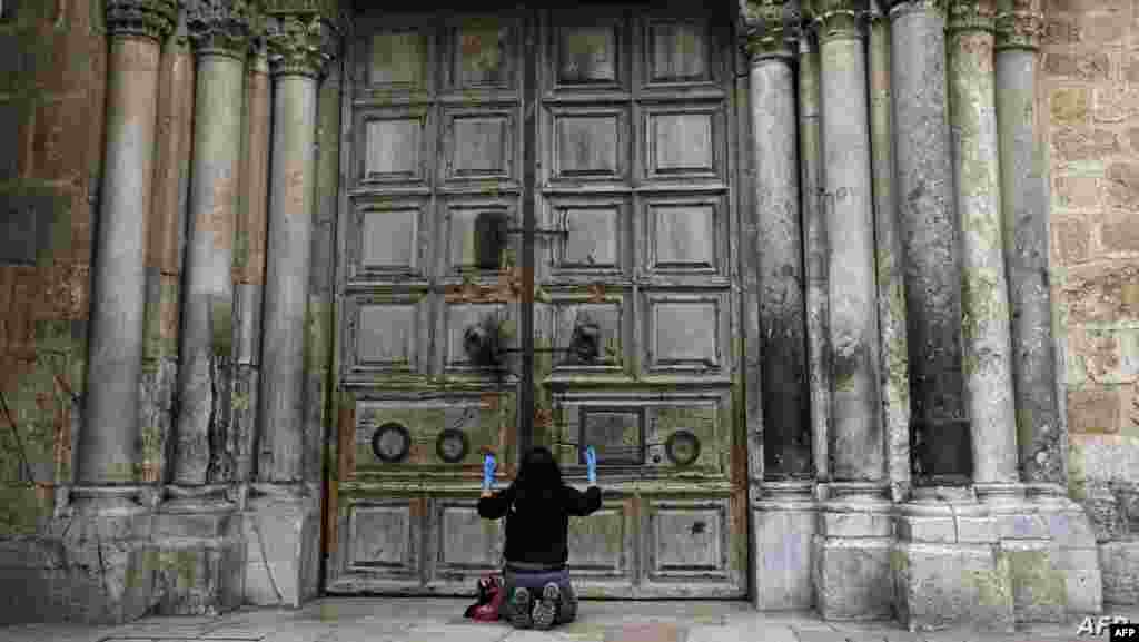 이스라엘 예루살렘에서 신종 코로나바이러스 감염증(코로나19) 확산 방지를 위해 집회 제한 조치가 내려진 가운데 유대교 신자가 성묘교회 앞에서 기도를 하고 있다. 