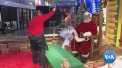 워싱턴 D.C.인근 한 쇼핑몰에 마련된 '산타와 사진찍기'공간에서 직원이 산타 앞에 세워진 투명 가림막을 소독하고 있다.