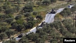 Tanques sirios vistos desde la aldea turca de Hatay Saribuk, en la provincia a lo largo de la frontera turco-siria.