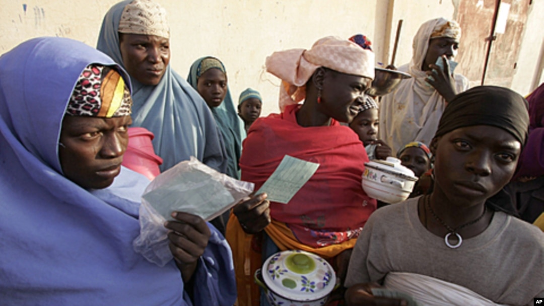 People stand in a food queue at the small town of Tchadoua around 40 kilometers from the town of Maradi, Niger, FILE July 24, 2005.