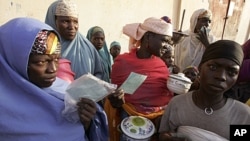 People stand in a food queue at the small town of Tchadoua around 40 kilometers from the town of Maradi, Niger, FILE July 24, 2005.