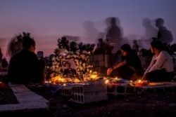 Familiares visitan la tumba de un combatiente de las Fuerzas Democráticas Sirias muerto durante una ofensiva turca en Qamishli, en el norte de Siria. Oct. 31 de 2019.