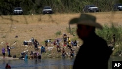 Migrants, many from Haiti, wade across the Rio Grande from Del Rio, Texas, to return to Ciudad Acuna, Sept. 22, 2021, some to avoid possible deportation from the U.S. and others to get supplies.