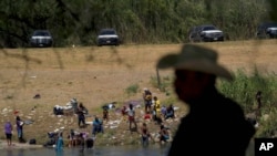 Migrants, many from Haiti, wade across the Rio Grande from Del Rio, Texas, to return to Ciudad Acuna, Sept. 22, 2021, some to avoid possible deportation from the U.S. and others to get supplies.