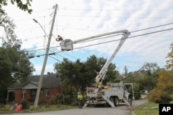 A Dominion Energy lineman works on a power line in the aftermath of Hurricane Helene, Sept. 29, 2024, in North Augusta, South Carolina.