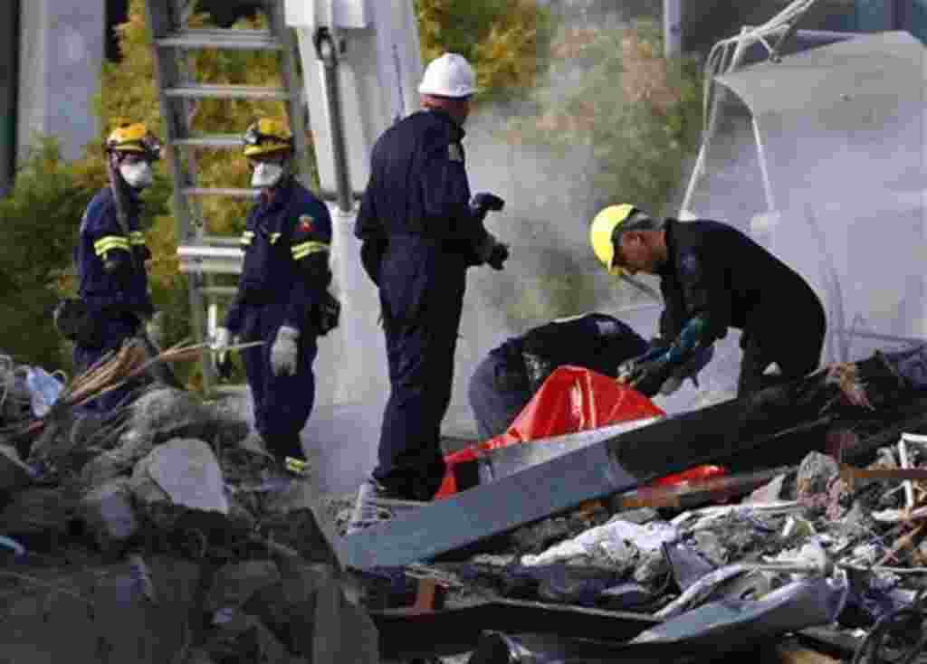 Emergency workers prepare to remove a body from the site of the CTV building in Christchurch, New Zealand, February 24, 2011, after the city was hit by a 6.3 magnitude earthquake Tuesday.