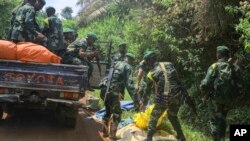 FILE - Congolese Defense Forces soldiers remove the bodies of victims of an attack near the town of Oicha, 30 kms from Beni, DRC, on July 23, 2021. Over 30 were killed by the militia groups CODECO and the Allied Democratic Forces, which is allied to the Islamic State group.