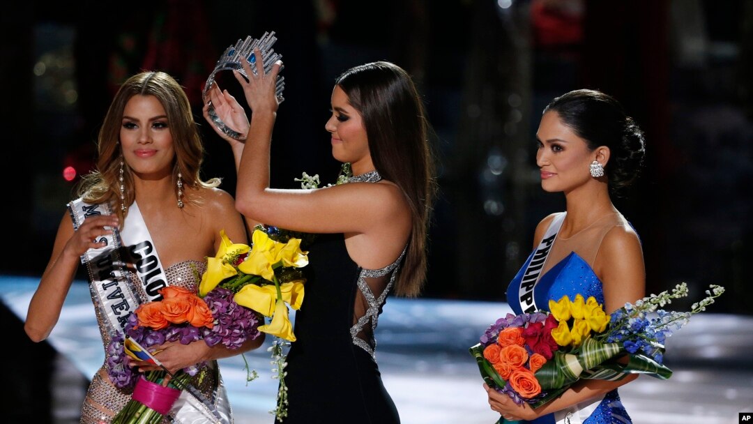Former Miss Universe Paulina Vega, center, removes the crown from Colombia's Ariadna Gutierrez, left, before giving it to the Philippines' Pia Alonzo Wurtzbach, right, at the pageant in Las Vegas, Nev., Dec. 20, 2015.