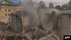 Emergency and rescue personnel along with medics and others clear the rubble of the destroyed building of Ohmatdyt Children's Hospital following a Russian missile attack in the Ukrainian capital of Kyiv on July 8, 2024, amid Russian invasion in Ukraine.