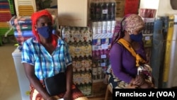 Duas mulheres deslocadas esperam pelos seus produtos dentro de uma loja contratada pelo PMA para fornecer produtos aos que fogem da violência armada no norte de Cabo Delgado. Moçambique