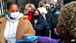 Un grupo de personas hace fila para recibir pruebas diagnósticas de COVID-19, distribuidas en Nueva York el 23 de diciembre de 2021. 