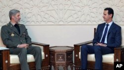 Menteri Pertahanan Iran Amir Hatami (kiri) bertemu Presiden Suriah Bashar al-Assad di Damaskus, Minggu (26/8). 