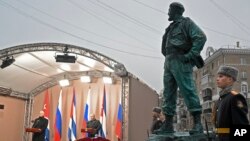 Cuba's President Miguel Diaz-Canel Bermudez, left, and Russian President Vladimir Putin take part in the unveiling ceremony of a monument to the late Cuban leader Fidel Castro, right, in Moscow, Russia, Nov. 22, 2022. 