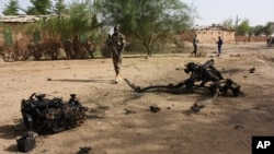 ARCHIVES - Des soldats nigériens sur le lieu où des kamikazes se sont fait exploser à l'intérieur d'une caserne militaire, à Agadez, dans le nord du Niger, le 23 mai 2013.