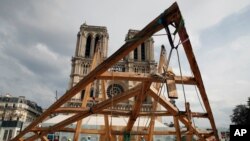 Carpenters put the skills of their medieval colleagues on show in front of Notre Dame Cathedral in Paris, France, Sept. 19, 2020, by reproducing for the public a section of the elaborate carpentry used when the edifice was built.