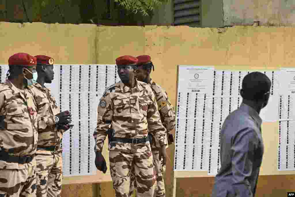 Oficiais do exército chadiano patrulham junto a um caderno eleitoral numa assembleia de voto em N&#39;Djamena, a 6 de maio de 2024, durante as eleições presidenciais no Chade.