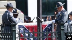 Petugas patroli jalan raya South Carolina menurunkan bendera konfederasi dari Gedung Capitol di Columbia, South Carolina, Jumat (10/7).