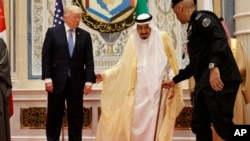 FILE - U.S. President Donald Trump, left, stands with Saudi King Salman as he is helped by his bodyguard during a photo with leaders at the Gulf Cooperation Council meeting, in Riyadh, Saudi Arabia, May 21, 2017.