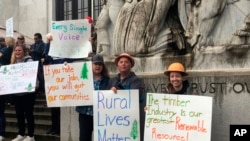 Protesters converge outside the Oregon Capitol in Salem, Ore., June 27, 2019. Truckers, loggers and farmers say they support the 11 Republican senators who walked out over a week ago to avoid a vote on climate legislation.