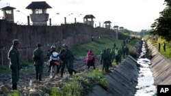FILE - Soldiers and policemen secure the perimeter of Palmasola prison, in Santa Cruz, Bolivia, July 10, 2015.