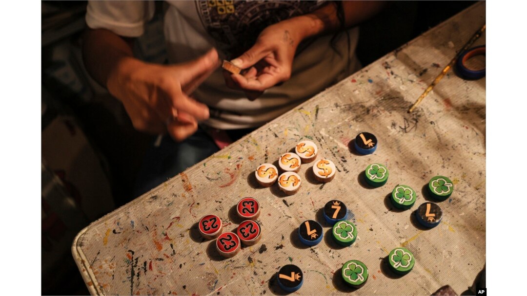 FILE - Dana Lopez sands a wooden token for poleana, a board game invented in prison, in his workshop in Mexico State, Mexico, Oct. 25, 2024.