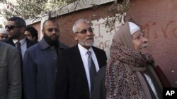 Muslim Brotherhood leader Mohammed Badie, second right, waits in line outside a polling place in Beni Suef, Egypt, to vote on a constitution drafted by Islamist supporters of President Morsi, Dec. 22, 2012.