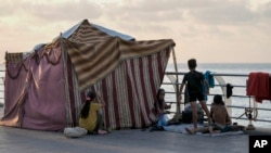 A displaced family, fleeing the Israeli airstrikes in the south, sits next to their tent on Beirut's corniche, Lebanon, Oct. 14, 2024.