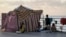 A displaced family, fleeing the Israeli airstrikes in the south, sits next to their tent on Beirut's corniche, Lebanon, Oct. 14, 2024.