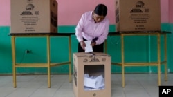 FILE - A woman casts her ballot during a presidential runoff election, in Quito, Ecuador, April 2, 2017.