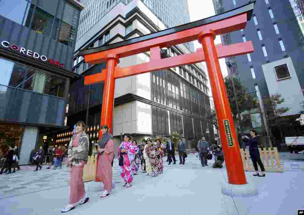 Beberapa turis asing memakai pakaian tradisional Jepang kimono saat memasuki sebuah kuil di dekat distrik Nihonbashi, Tokyo.