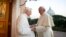 Pope Emeritus Benedict XVI, left, welcomes Pope Francis as they exchange Christmas greetings, at the Vatican, Dec. 23, 2013. 