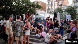 FILE PHOTO: Tourists and residents drink on a street in Gracia neighbourhood during a heatwave of the summer, in Barcelona