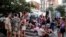 FILE PHOTO: Tourists and residents drink on a street in Gracia neighbourhood during a heatwave of the summer, in Barcelona