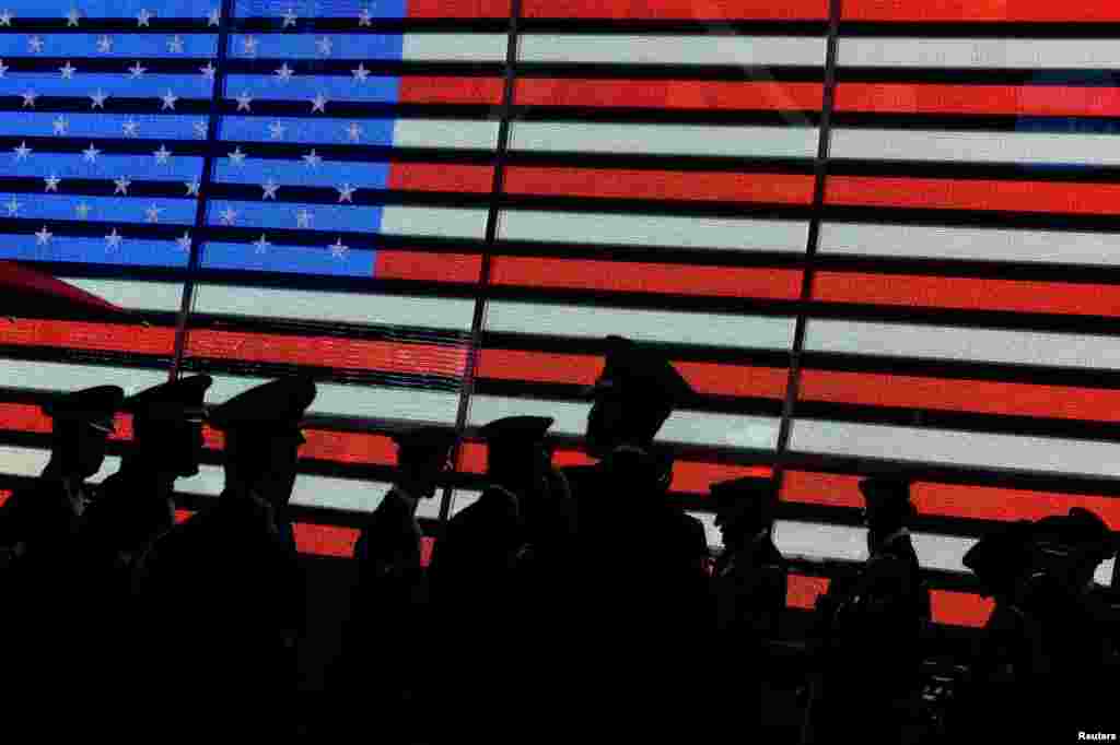 Members of a United States Air Force (USAF) Honor Guard team gather in the early morning beneath an electronic American flag sign in Times Square, in New York City, New York.