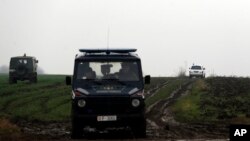 Military vehicles drive to the site of a helicopter crash on the outskirts of Belgrade, Serbia, Saturday, March 14, 2015. 