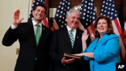 FILE - Speaker of the House Paul Ryan, R-Wis. (L), Representative-elect Karen Handel, R-Ga.(R), and her husband Steve Handel participate in a ceremonial swearing-in on Capitol Hill in Washington, June 26, 2017. 