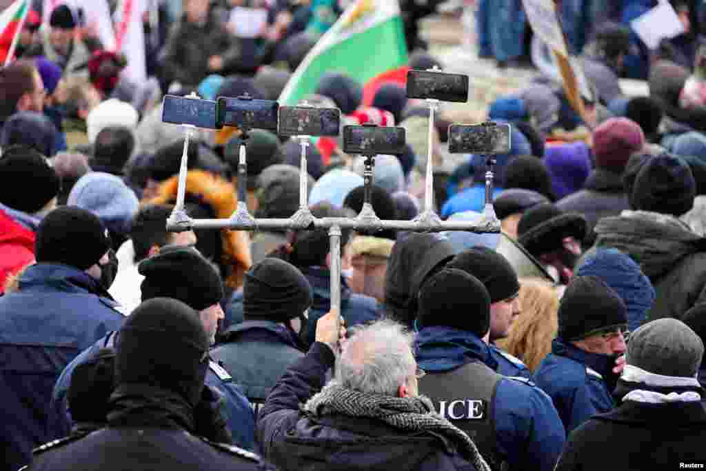 A man uses multiple devices to live stream as he participates in a rally against the government measures to curb the spread of the COVID-19 in Sofia, Bulgaria, Jan. 12, 2022