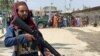 FILE - A member of the Taliban forces stands guard at the Pakistan-Afghanistan crossing border, in Torkham, Pakistan, September 2, 2021. 