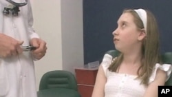 Romanian Andrea Nemethi, 12, speaks with Doctor Aaron Fay, a surgeon at Massachusetts Eye and Ear Infirmary