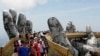 Tourists walk along Gold Bridge on Ba Na hill near Danang city, Vietnam, Aug. 1, 2018. 