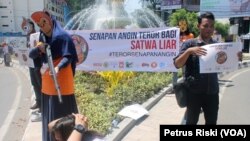 Belasan aktivis peduli satwa dari Centre for Orangutan Protection (COP) didukung 10 organisasi pelindung satwa liar lainnya, melakukan aksi teaterikal dan kampanye pengetatan dan pengawasan penggunaan senapan angin, 14 September 2016 (Foto: VOA/Petrus Riski)