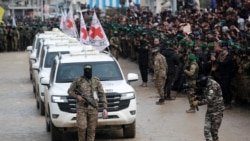 Anggota pasukan Hamas berjalan di depan kendaraan Palang Merah saat mereka tiba di kamp Nuseirat di Jalur Gaza untuk menerima tiga sandera Israel dalam proses pertukaran sandera dan tahanan antara Hamas dan Israel pada 22 Februari 2025. (Foto: AFP/Bashar Taleb)