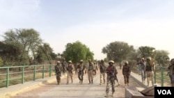 Des soldats nigériens traversent le pont Doutchi.