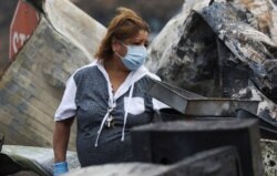 Maria Arevalo searches for items to salvage in the remains of her burned home in Phoenix, Ore., Sept. 22, 2020.