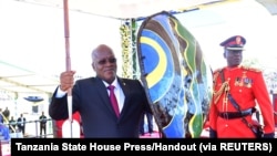 Le président John Magufuli, tient une lance et un bouclier reçus des chefs traditionnels après avoir prêté serment pour son second mandat au stade Jamhuri de Dodoma, en Tanzanie, le 5 novembre 2020.